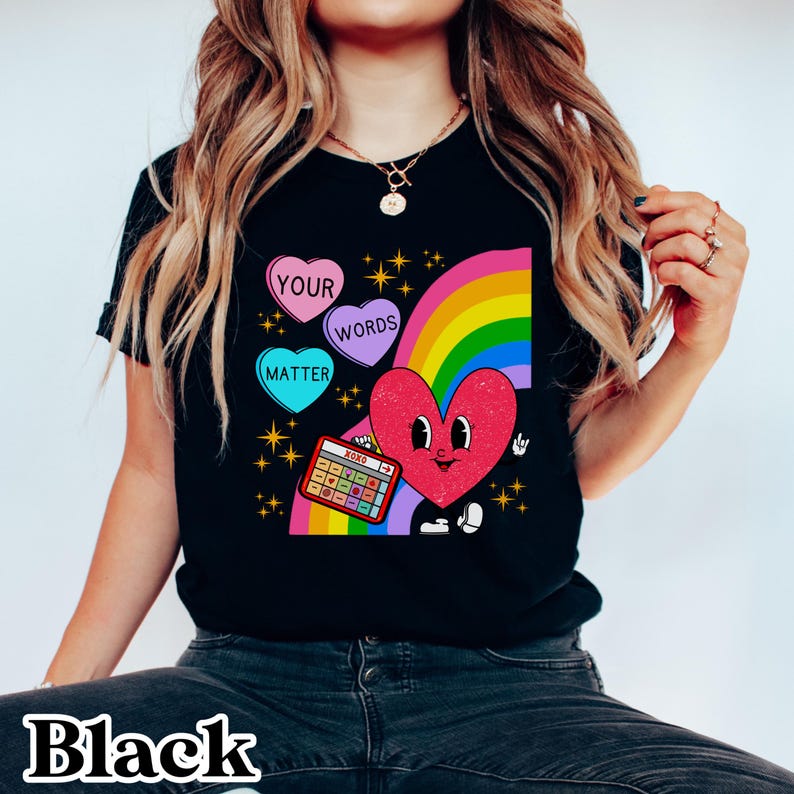 May include: Black t-shirt featuring a rainbow, a heart with a face, and candy hearts that say "Your Words Matter".