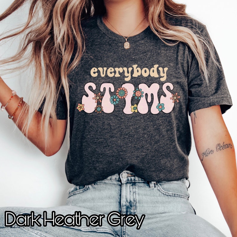 May include: Dark heather grey t-shirt with the text "everybody stims" in pink and yellow letters with flowers around the text.