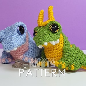 May include: Two crocheted stuffed toy dragons. One is light blue with pink accents and the other is green with yellow accents. Both have large black eyes.