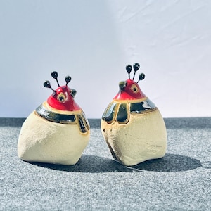 May include: A set of three ceramic mugs with a speckled, matte finish. The mugs are in shades of cream, light gray, and dark gray. Each mug has a simple, minimalist design, perfect for coffee or tea.