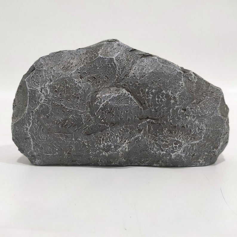 May include: A large, gray, irregularly shaped rock with a rough, textured surface. The rock is made of a lightweight material and is ideal for use in model train layouts, miniature gardens, or other craft projects.