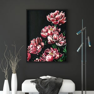K&ouml;nnte beinhalten: Ein gerahmtes Gem&auml;lde von rosa Pfingstrosen auf schwarzem Hintergrund. Das Gem&auml;lde h&auml;ngt an einer schwarzen Wand mit einem wei&szlig;en Sofa und einer schwarzen und blauen Stehlampe davor.