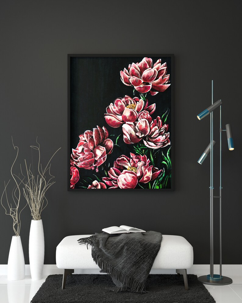 K&ouml;nnte beinhalten: Ein gerahmtes Gem&auml;lde von rosa Pfingstrosen auf schwarzem Hintergrund. Das Gem&auml;lde h&auml;ngt an einer schwarzen Wand mit einem wei&szlig;en Sofa und einer schwarzen und blauen Stehlampe davor.