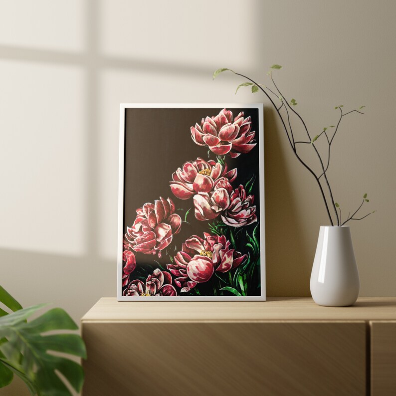 K&ouml;nnte beinhalten: Ein gerahmter Druck eines Blumenarrangements mit rosa Pfingstrosen auf einem dunklen Hintergrund. Die Pfingstrosen sind in einer kaskadierenden Anordnung angeordnet, wobei die Bl&uuml;ten nach oben zeigen. Der Druck ist in einem wei&szlig;en Rahmen gerahmt.