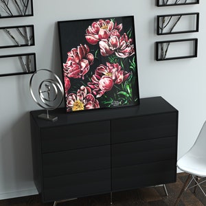 K&ouml;nnte beinhalten: Ein schwarzer gerahmter Druck eines Gem&auml;ldes mit rosa Pfingstrosen auf dunklem Hintergrund. Der Druck h&auml;ngt an einer wei&szlig;en Wand &uuml;ber einer schwarzen Kommode mit sechs Schubladen. Eine silberne Metallskulptur steht auf der Kommode links neben dem Druck.