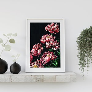 K&ouml;nnte beinhalten: Ein gerahmter Druck eines Blumenarrangements mit rosa Pfingstrosen auf schwarzem Hintergrund. Die Pfingstrosen sind in einer Gruppe angeordnet, wobei einige Bl&uuml;ten zum Betrachter zeigen und andere abgewandt sind. Der Druck ist in einem wei&szlig;en Rahmen gerahmt.
