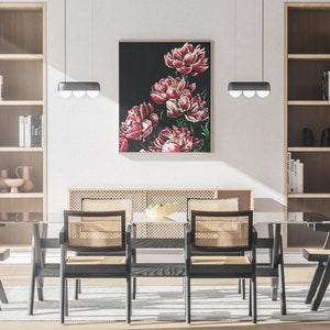 May include: A dining room with a glass table and six black chairs with woven cane seats. The table is set with a bowl of fruit and a floral painting hangs on the wall behind it.
