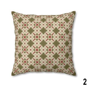 Pode incluir: Uma almofada decorativa com um padr&atilde;o geom&eacute;trico em tons de verde e vermelho sobre um fundo creme.