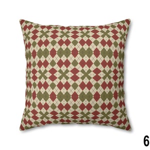 Pode incluir: Uma almofada decorativa com um padr&atilde;o argyle vermelho e verde. A almofada &eacute; feita de um tecido macio e texturizado.