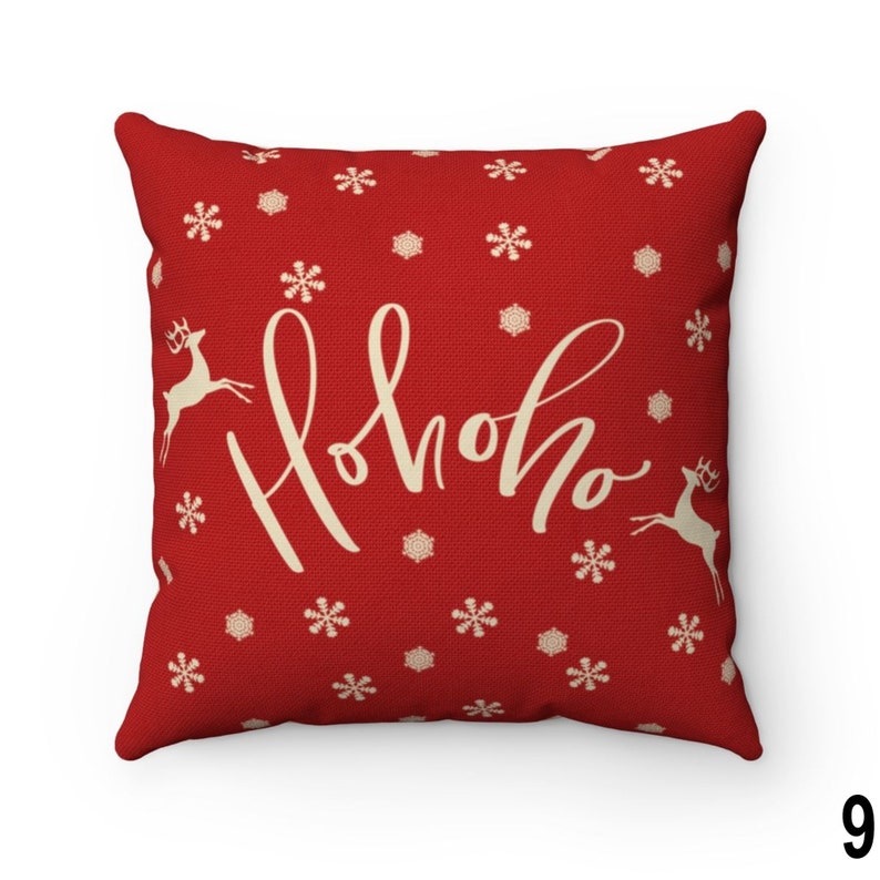 Pu&ograve; includere: Un cuscino quadrato rosso con un design festivo. Il cuscino presenta il testo "Hohoho" in un carattere corsivo, insieme a illustrazioni di fiocchi di neve e renne. Lo sfondo &egrave; di colore rosso pieno.