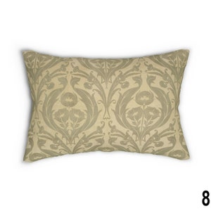 May include: A beige throw pillow with a green floral pattern. The pattern features stylized leaves and flowers.
