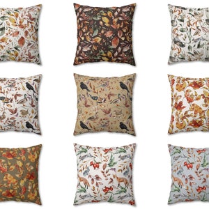 May include: Nine square throw pillows with various nature-themed patterns. Designs include autumn leaves, birds, and foxes in shades of brown, orange, and green. The pillows are arranged in a three-by-three grid.