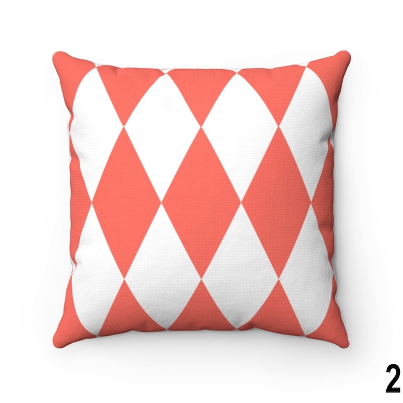 May include: A coral and white diamond patterned cushion. The cushion is made of a soft, comfortable fabric and is perfect for adding a touch of colour and style to any room.