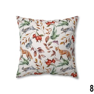 May include: Square throw pillow with a repeating pattern of foxes, rabbits, and berries among autumn leaves. The design features watercolor illustrations in shades of orange, gray, green, and brown on a cream background.