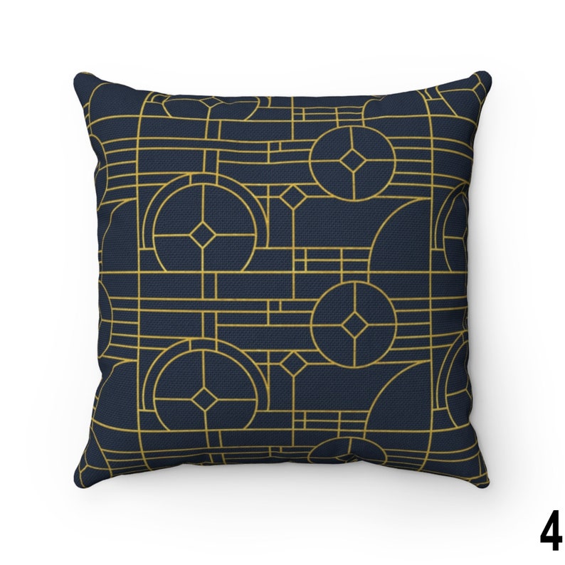 May include: A navy blue throw pillow with a geometric pattern in gold. The pattern features circles, squares, and diamonds.