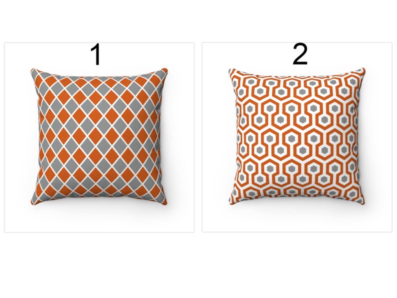 K&ouml;nnte beinhalten: Zwei dekorative Kissen mit geometrischen Mustern. Das Kissen links hat ein Rautenmuster in Orange und Grau. Das Kissen rechts hat ein Wabenmuster in Orange und Grau.