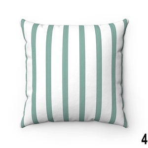 May include: A white throw pillow with green stripes. The pillow is made of a soft, comfortable fabric and is perfect for adding a touch of style to any room.