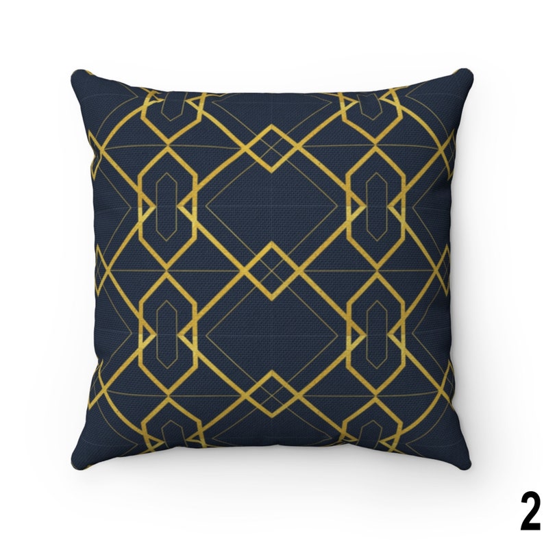 May include: A navy blue throw pillow with a gold geometric pattern. The pattern is made up of overlapping squares and rectangles.