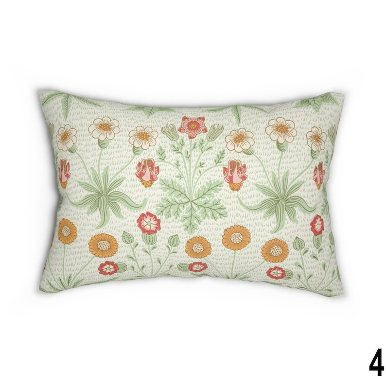 May include: A rectangular throw pillow with a floral pattern. The pillow features a white background with a repeating pattern of green leaves, orange and red flowers, and white flowers.