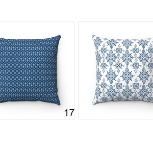 May include: Two decorative throw pillows with blue and white geometric patterns. The pillow on the left has a repeating pattern of small white hexagons on a dark blue background. The pillow on the right has a larger, more intricate pattern of white shapes on a white background.