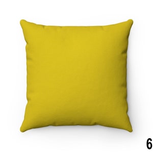 Puede incluir: Una almohada de sof&aacute; de color amarillo brillante con una tela lisa y texturizada. La almohada tiene forma cuadrada y un dise&ntilde;o simple.