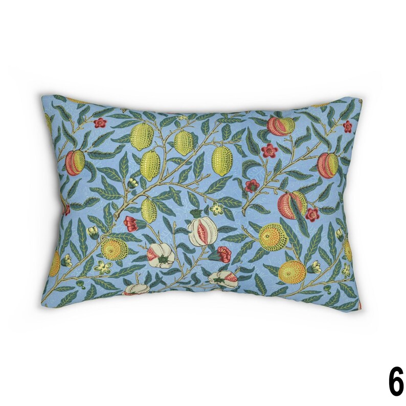 May include: A light blue throw pillow with a floral pattern featuring lemons, pomegranates, and leaves. The pillow has a subtle textured surface.