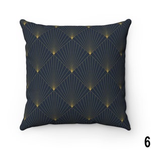 May include: A navy blue throw pillow with a geometric pattern of gold fans. The pillow is made of a soft, textured fabric.
