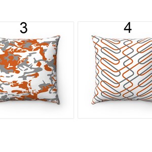 K&ouml;nnte beinhalten: Zwei dekorative Kissen mit unterschiedlichen Mustern. Das Kissen links hat ein Tarnmuster in Orange, Grau und Wei&szlig;. Das Kissen rechts hat ein geometrisches Muster in Orange, Grau und Wei&szlig;.