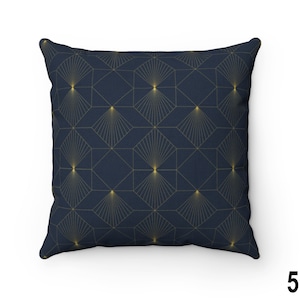May include: A navy blue throw pillow with a geometric pattern of gold hexagons and radiating lines.