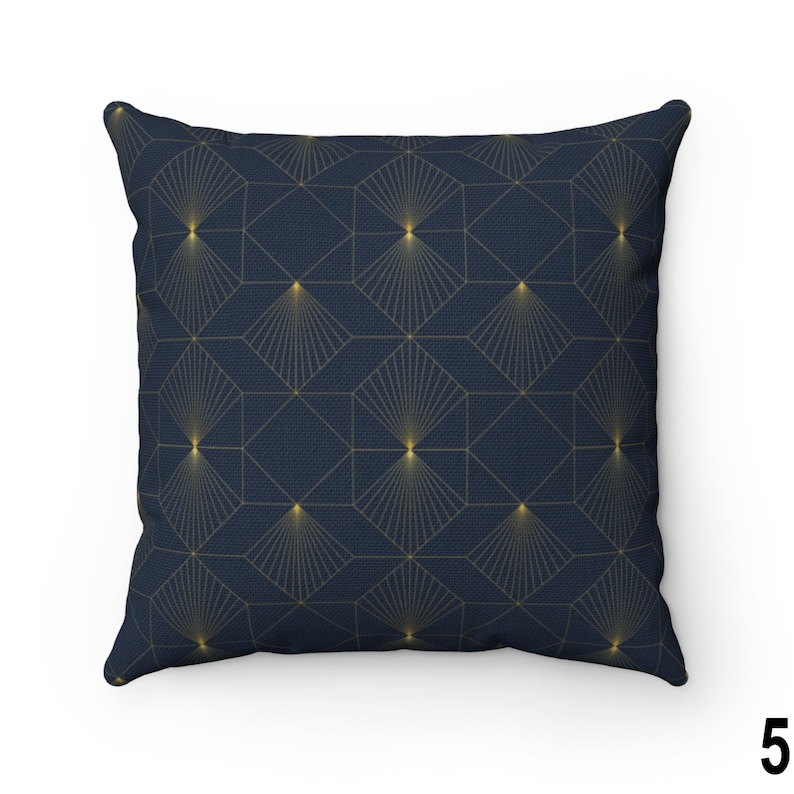 May include: A navy blue throw pillow with a geometric pattern of gold hexagons and radiating lines.