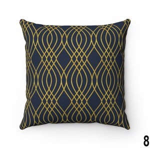 May include: A navy blue throw pillow with a gold geometric pattern. The pattern is made up of repeating curved lines that create a lattice effect.