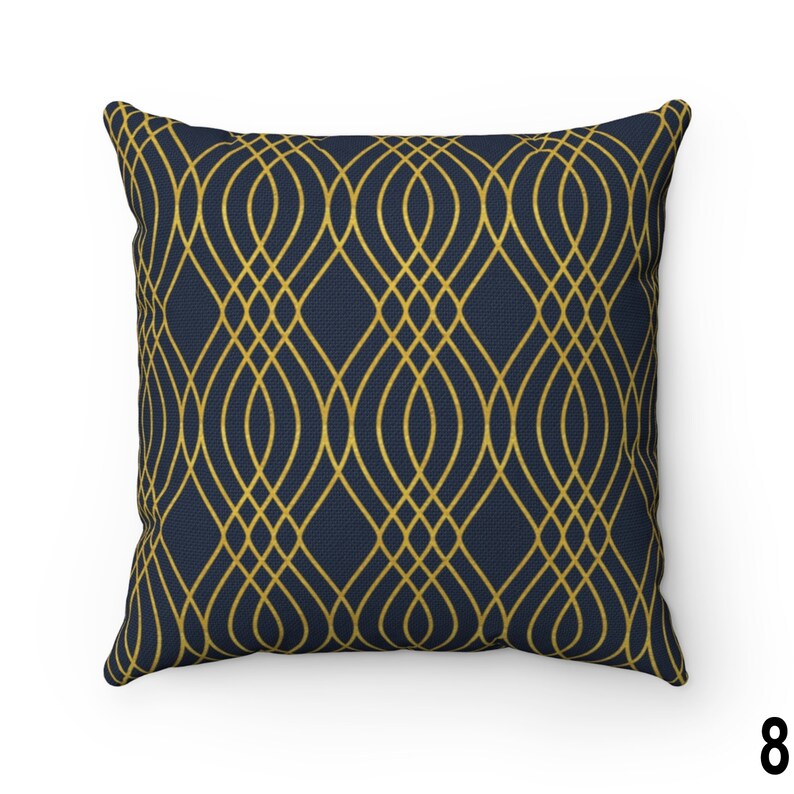 May include: A navy blue throw pillow with a gold geometric pattern. The pattern is made up of repeating curved lines that create a lattice effect.