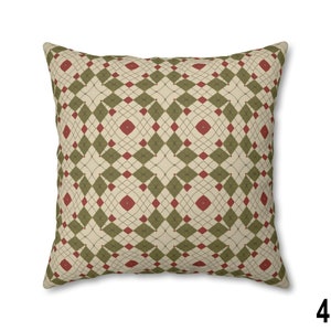 Pode incluir: Uma almofada decorativa com um padr&atilde;o geom&eacute;trico em tons de verde, vermelho e creme. O padr&atilde;o apresenta uma forma de diamante repetida com um design de linha fina e intrincado.