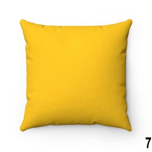 Puede incluir: Una almohada de sof&aacute; de color amarillo brillante con una tela suave y texturizada. La almohada tiene forma cuadrada y un dise&ntilde;o simple.