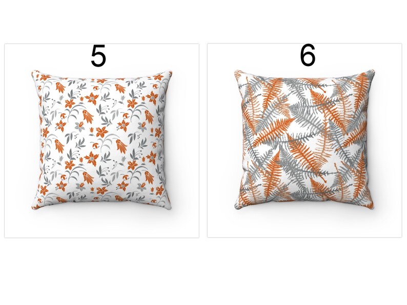 K&ouml;nnte beinhalten: Zwei dekorative Kissen mit unterschiedlichen Mustern. Das Kissen links hat einen wei&szlig;en Hintergrund mit einem sich wiederholenden Muster aus orangefarbenen Blumen und grauen Bl&auml;ttern. Das Kissen rechts hat einen wei&szlig;en Hintergrund mit einem sich wiederholenden Muster aus orangefarbenen und grauen Farnbl&auml;ttern. Beide Kissen haben einen grauen Rand.