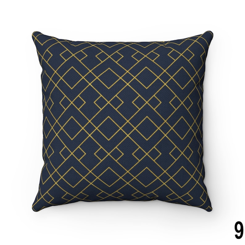May include: A navy blue throw pillow with a geometric pattern of gold lines forming squares.