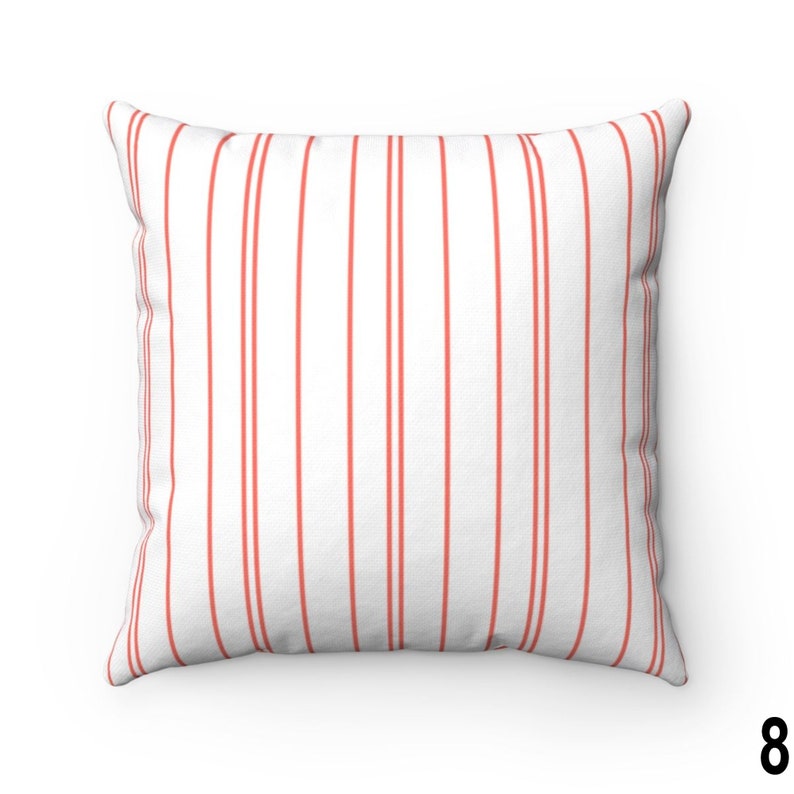 May include: A white cushion with red vertical stripes. The cushion is made from a soft, comfortable fabric and is ideal for adding a touch of colour and style to any room.