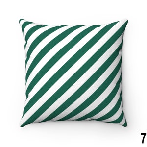 May include: A green and white striped throw pillow with a diagonal pattern. The pillow is made of a soft, comfortable fabric and is perfect for adding a touch of style to any room.