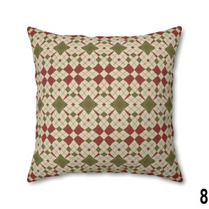 Pode incluir: Uma almofada decorativa com um padr&atilde;o de diamantes vermelho, verde e creme.