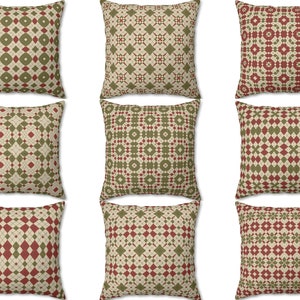 Pode incluir: Nove almofadas decorativas com um padr&atilde;o geom&eacute;trico em tons de verde, vermelho e creme.