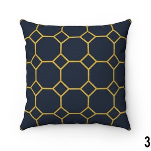 May include: A navy blue throw pillow with a geometric pattern of gold octagons.
