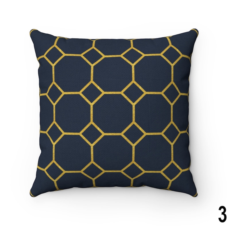 May include: A navy blue throw pillow with a geometric pattern of gold octagons.