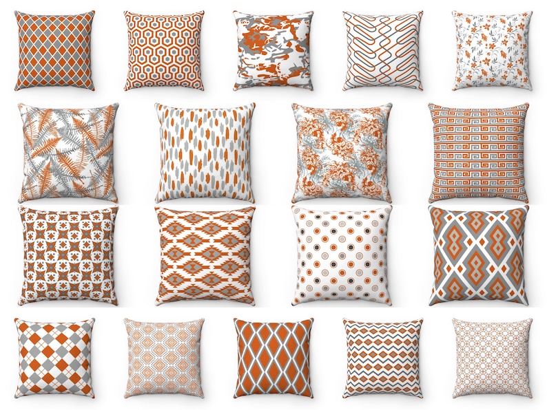 K&ouml;nnte beinhalten: Ein Set mit 16 dekorativen Kissen mit verschiedenen geometrischen Mustern in Orange-, Grau- und Wei&szlig;t&ouml;nen. Die Kissen sind in einem Raster auf wei&szlig;em Hintergrund angeordnet.