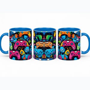 May include: A ceramic mug featuring a vibrant, multi-coloured pattern of various video game controllers in shades of pink, orange, blue, and green against a black background, with a solid bright blue handle and a matching blue interior rim.