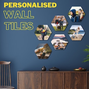 Può includere: Sei piastrelle da parete esagonali con diverse foto di famiglia stampate su di esse. Le piastrelle sono disposte a forma di motivo su una parete blu. Le piastrelle sono realizzate in un materiale resistente e sono facili da appendere.