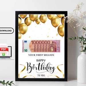 May include: A framed print with a black border features gold balloons, a 1,000,000 Euro bill, and the text "YOUR FIRST MILLION" and "HAPPY BIRTHDAY TO YOU." Gold ribbon accents the design. A white vase with flowers is to the right.