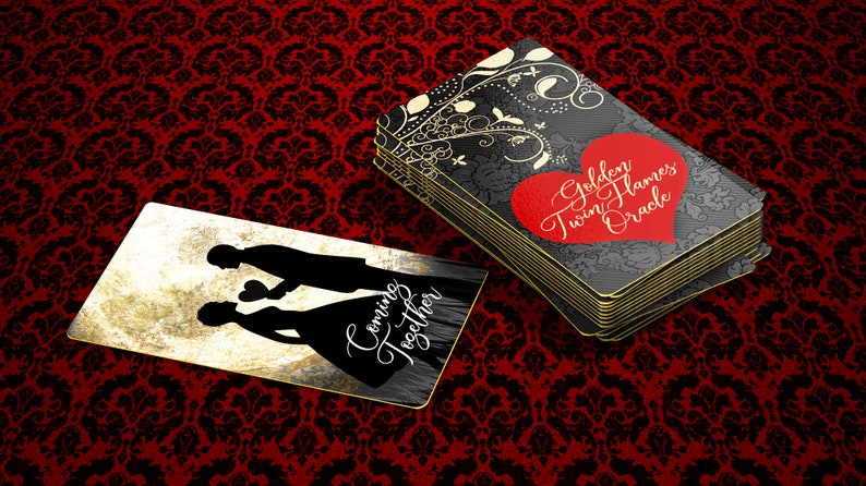 May include: A deck of Golden Twin Flames Oracle cards with a red heart and gold text. The cards have a black floral design and gold edges. A single card shows silhouettes of a couple with the text "Coming Together".