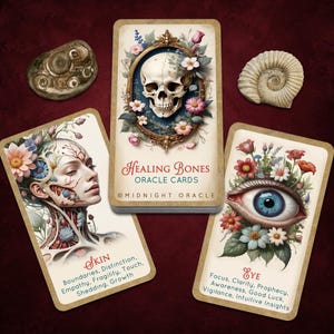 May include: A deck of Healing Bones Oracle Cards by Midnight Oracle featuring a skull in a floral frame, a card with a human face and floral anatomy labeled Skin, and a card with a large blue eye and flowers labeled Eye, with two fossils.