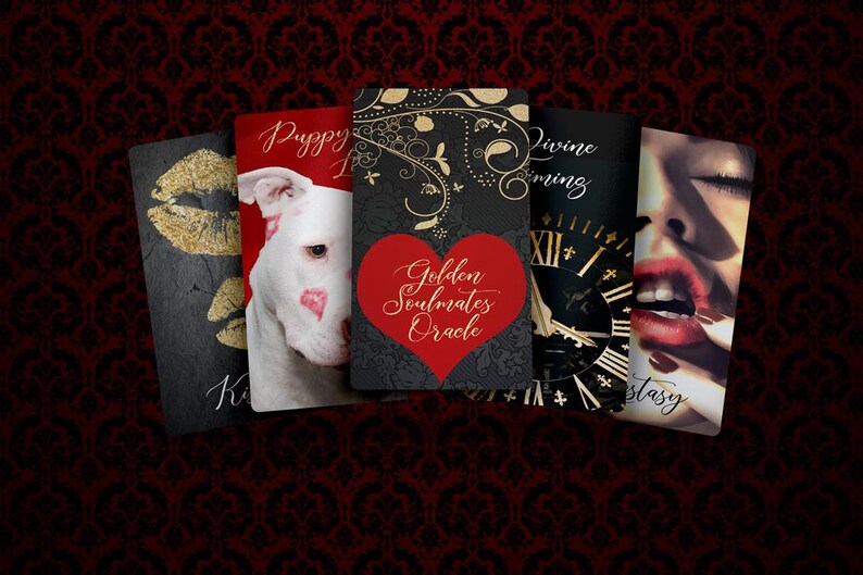 Może przedstawiać: Kolekcja kart do wr&oacute;żenia z r&oacute;żnymi wzorami. Jedna karta przedstawia złote usta, inna białego psa z pocałunkami szminki, a trzecia czerwone serce i napis "Golden Soulmates Oracle". Tło to ciemnoczerwony wz&oacute;r damasceński.