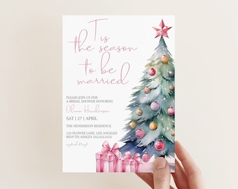 Könnte beinhalten: Eine rosafarbene und weiße Hochzeitseinladung mit einer Aquarell-Illustration eines Weihnachtsbaums mit Ornamenten und Geschenken. Der Text lautet "Es ist die Zeit zum Heiraten".